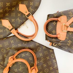 High-end designer leather handbags with monogram pattern lay elegantly displayed.